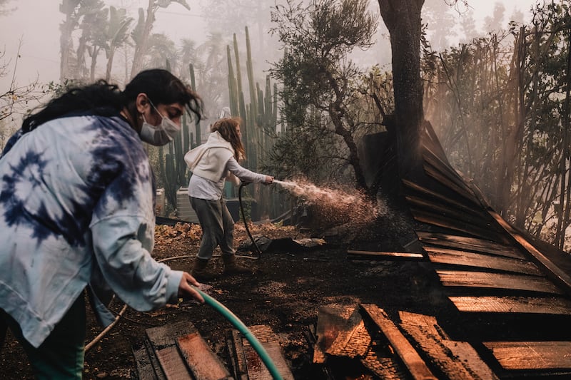 Irma Alvarado and Nancy Chiamulon try to contain a fire encroaching on Chiamulon’s property during the Palisades fire in Los Angeles. Photograph: Mark Abramson/New York Times