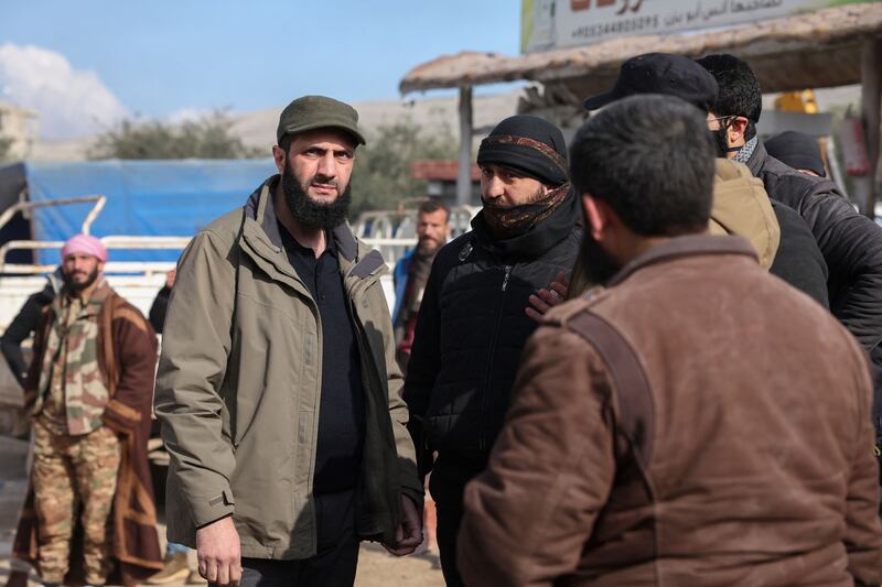 Hayat Tahrir al-Sham (HTS) jihadist group's chief Abu Mohamed al-Jolani (L) checks the damage following an earthquake in the village of Besnaya in Idlib province. Photograph: Omar Haj Kadour/AFP via Getty Images