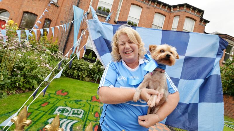 Lisa Connolly with her Yorkshire Terrier Coco at her home on Clonliffe Road with the Dublin crest painted on the grass. Photograph: Alan Betson