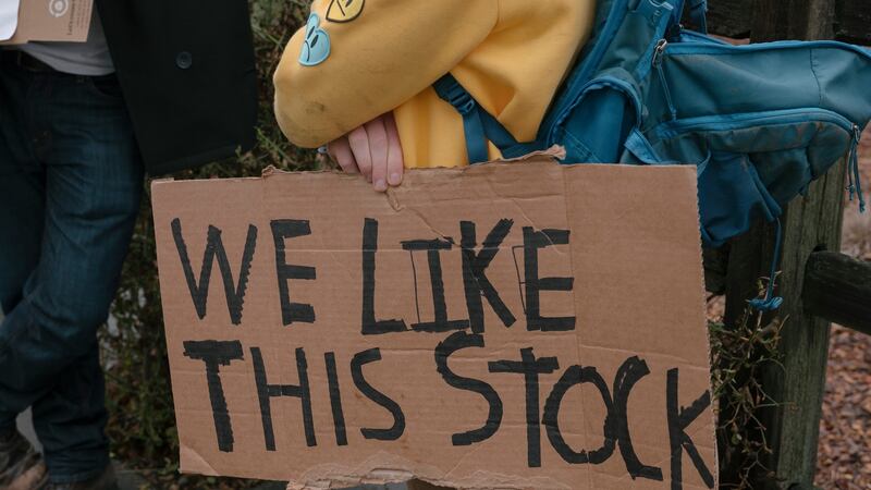 A protester holds a sign outside   Robinhood’s headquarters in  California on Thursday after the stock-trading app said it would limit trades in GameStop. Photograph: The New York Times