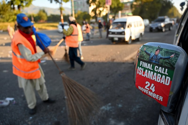 Municipal workers clean a street in Islamabad  after an overnight operation by security forces against supporters of jailed former Pakistani prime minister Imran Khan. Photograph: Aamir Qureshi/AFP via Getty Images