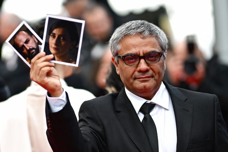 Mohammad Rasoulof holds portraits of The Seed of the Sacred Fig actors Missagh Zareh and Soheila Golestani at Cannes last May. Photograph: Loic Venance/Getty