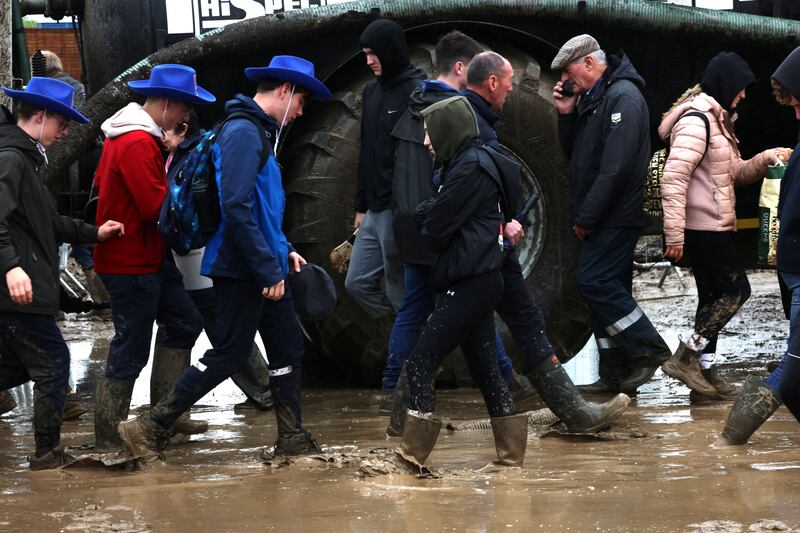 Attendees tackle the mud in the arena area. Photograph: Dara Mac Dónaill/The Irish Times