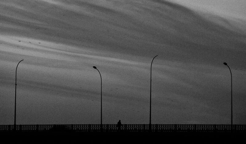 The photo accompanying a Baghdad Gazette article on the issue of suicide features the silhouette of a lone person on a bridge beneath an overcast sky. 'Sometimes I feel alone like this guy, as if I was the only person in the city.' Photograph: Ayman Al-Amiri