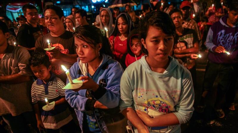 Indonesians hold candles during a vigil for the victims of the crashed AirAsia airplane in Surabaya, East Java, Indonesia. Photograph: Fully Handoko/EPA.