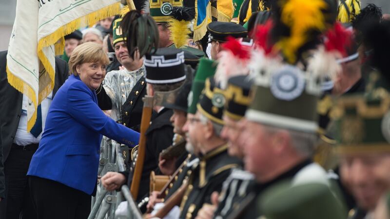 German chancellor Angela Merkel   greets people dressed in historic coal miner uniforms  as she arrives to attend festivities to celebrate the day of German unity in Dresden. Photograph: Sebastian Kahnert/AFP/Getty Images