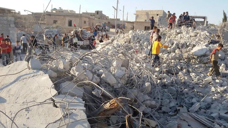 Syrian citizens check a damaged house that they say was targeted by the coalition air strikes, in the village of Kfar Derian, a base for the al-Qaida-linked Nusra Front, a rival of the Islamic State group, between the northern province of Aleppo and Idlib, Syria. Photograph: AP Photo