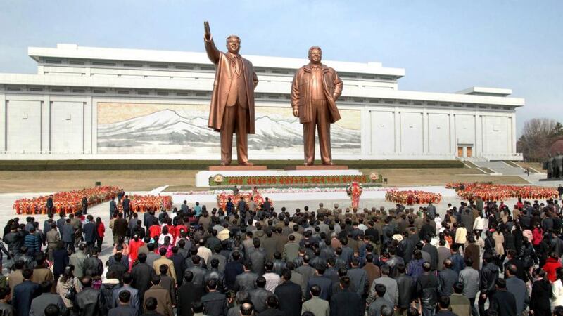 North Korean soldiers, workers and students place flowers before the statues of North Korean founder Kim Il-sung (L) and his son, late leader Kim Jong-il, on the 101st anniversary of Kim Il-sung's birth in Pyongyang today