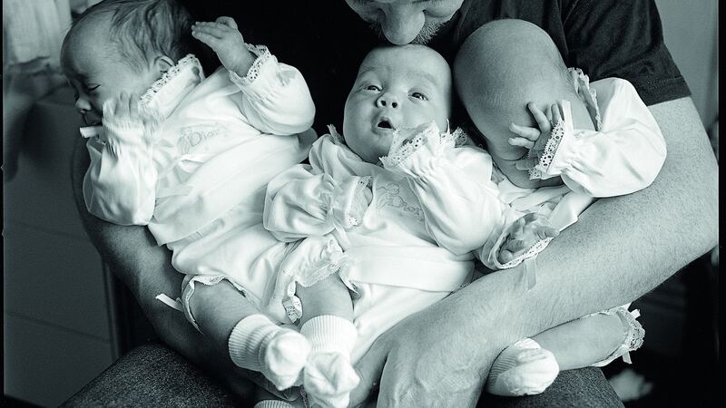 Philip King with his baby triplets, Ellen, Molly and Juno. Photograph: Amelia Stein