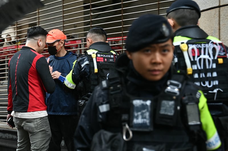 Police question a man outside the court in Hong Kong where Jimmy Lai was giving evidence on Wednesday. Photograph: Peter Parks/AFP via Getty Images