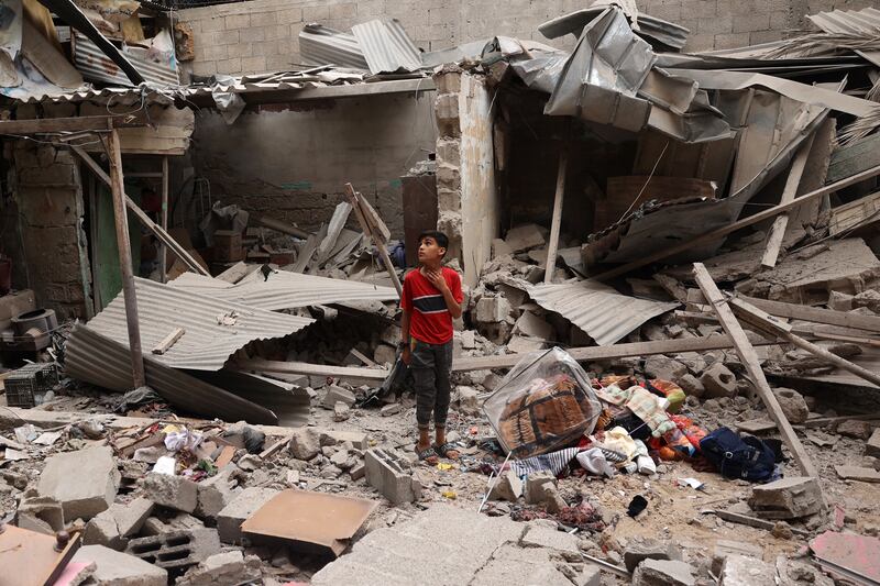 A Palestinian child stands near objects salvaged amid the debris of a house destroyed by overnight Israeli bombardment in Rafah in the southern Gaza Strip. Photograph: AFP/Getty