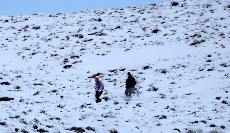 A couple make their way down the Tonlegge mountain in the snow in County Wicklow on Wednesday. Photograph: Eamonn Farrell/RollingNews.ie