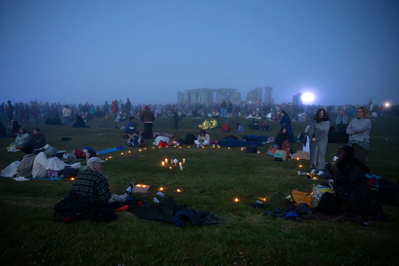 People wait by a circle of candles for the sun to rise at Stonehenge. Photograph: Finnbarr Webster/Getty