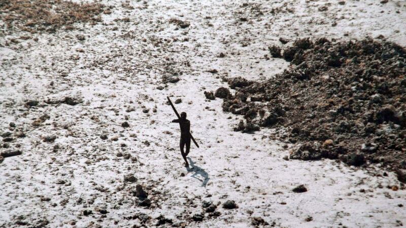 A man with the Sentinelese tribe aims his bow and arrow at an Indian coast guard helicopter as it flies over North Sentinel Island in the Andaman Islands after the 2004 Indian Ocean tsunami. Photograph:  AFP/Getty Images