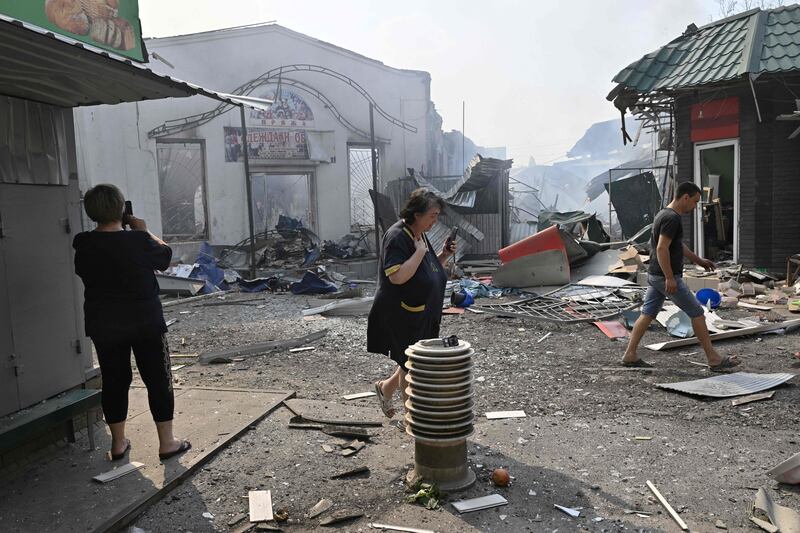 Local residents pass by destroyed shops after a rocket attack on a market in the Ukrainian town of Sloviansk on Sunday. Photograph: Genya Savilov/AFP via Getty Images