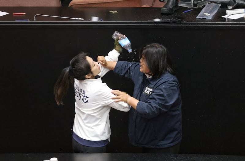 Taiwan opposition party Kuomintang (KMT) lawmaker Hsu Chiao-hsin (L) splashes water on Democratic Progressive Party (DPP) lawmaker Wang Mei-hui after the DPP occupied the night to avoid the passing of the third reading of amendments to the Civil Servants Election and Recall Act and other controversial bills at the Legislative Yuan in Taipei. Photograph: I-Hwa Cheng/AFP