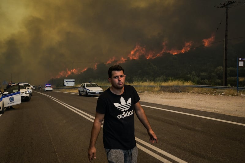 A man looks on as a wildfire burns in the village of Agios Charalabos, near Athens, on July 18th. Photograph: Aris Messini/AFP via Getty Images