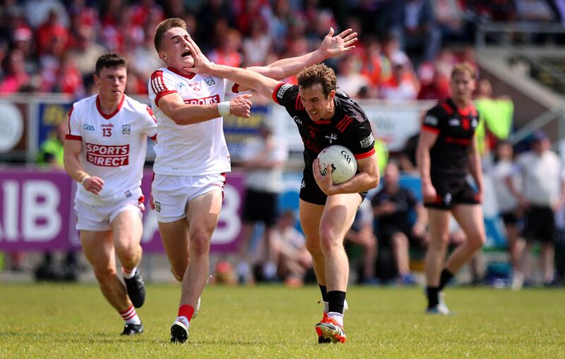 Louth’s Bevan Duffy holds off Tommy Walsh of Cork. Photograph: Ryan Byrne/Inpho