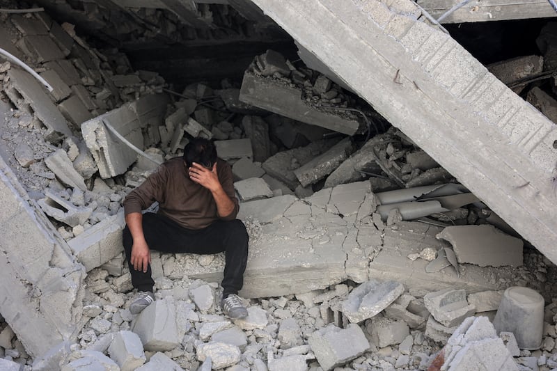 A Palestinian man sits amid the rubble of a building destroyed in an Israeli strike on the Shujaiyah neighbourhood in Gaza City. Photograph: Omar Al-Qattaa/AFP/Getty Images