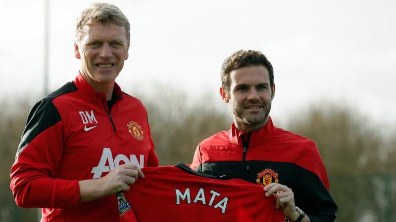 Manchester United’s new signing Juan Mata (right) holds a club shirt alongside manager David Moyes  at the club’s Carrington training comple. Photograph: Phil Noble/Reuters