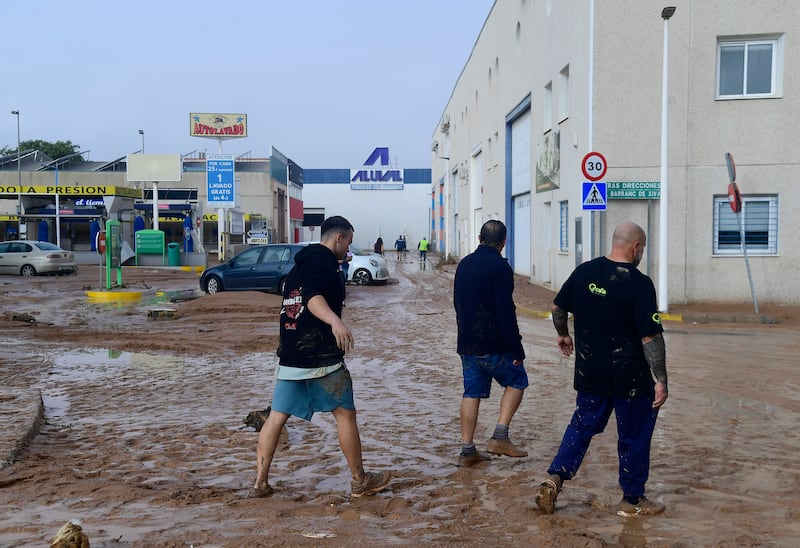 Men walk in a street covered in mud following floods in Picuana, near Valencia. Photograph: Getty Images