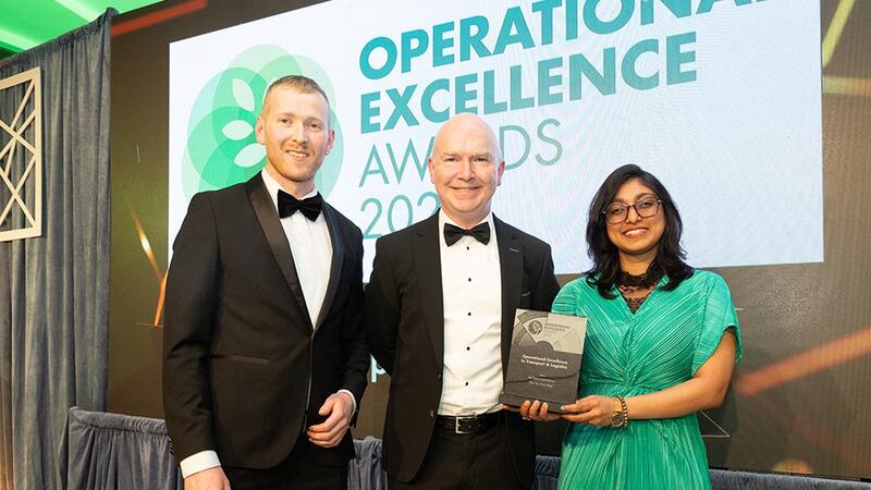 Neil Wall, community director at Business River presents the operational excellence in transport & logistics to Ned Hayden and Raksha Rao, An Post Commerce