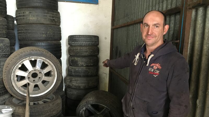 Paul Cassidy of Cassidy’s Tyre Centre at the junction of the R162 and N52 near Nobber in Co Meath points to the pile of tyres behind which a frightened east European man cowered on Thursday.  Photograph: Peter Murtagh