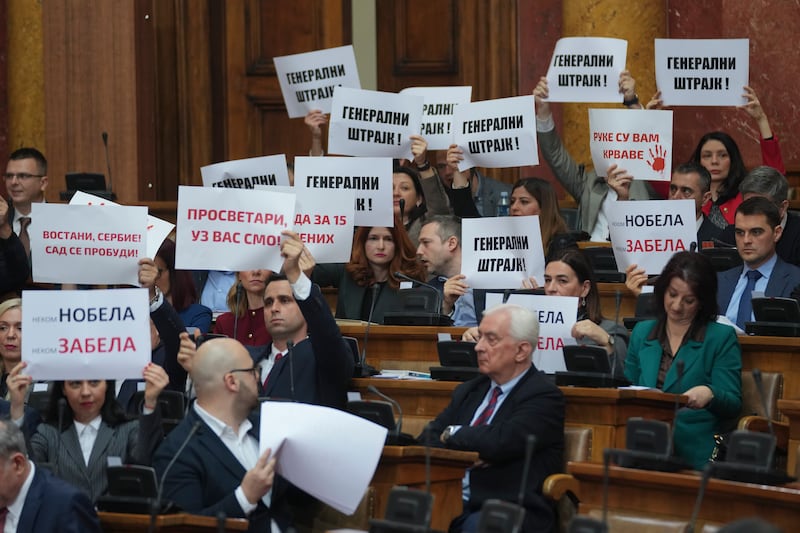 Opposition politicians held up banners which read ‘general strike’ during the parliamentary session (Darko Vojinovic/AP)