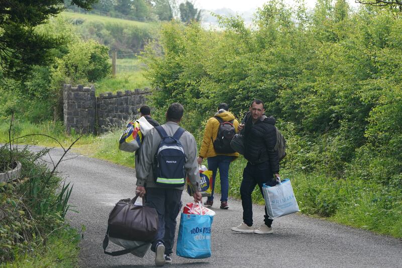 Asylum seekers, who told reporters they were heading for Dublin, leaving the grounds of the Magowna House hotel in Inch, Co Clare, on Tuesday. Photograph: Niall Carson/PA Wire