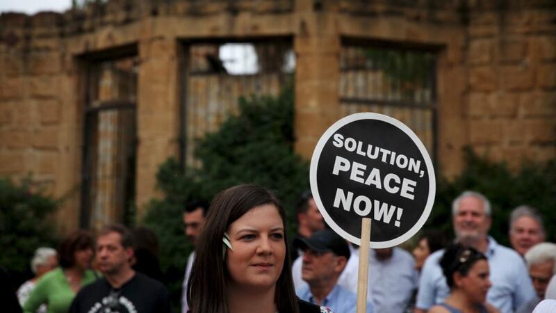 A woman holds a placard during a demonstration in favour of a peace settlement on divided Cyprus, outside a venue where leaders of estranged Greek and Turkish Cypriots met, in NicosiPhotograph:  Yiannis Kourtoglou/Reuters