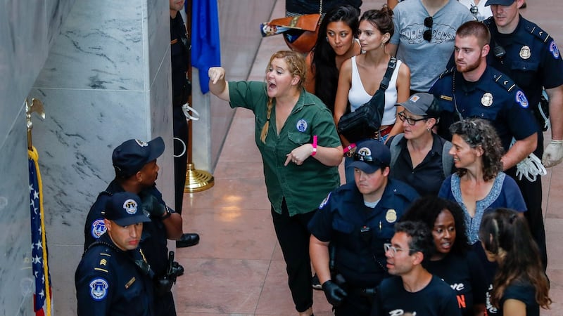 US comedian Amy Schumer gestures after getting detained along with hundreds of other protestors. Photograph:   EPA