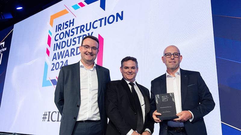 Gary O'Sullivan, construction director at Elliott Group, presents the consultancy of the year award to Philip Matthews and John Robinson, Turner & Townsend