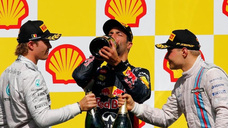 Red Bull’s  Daniel Ricciardo of Australia (centre) celebrates with champagne after winning the Belgian F1 Grand Prix in Spa-Francorchamps ahead of  Valtteri Bottas (right)  in third and  Nico Rosberg (left) in second . Photograph: Yves Herman / Reuters