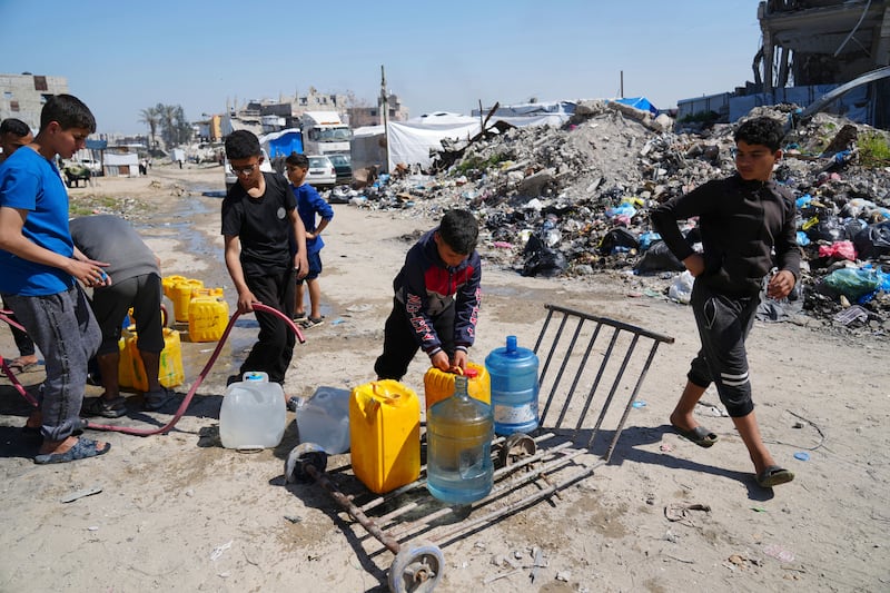 Palestinians fill cans with water in Jabaliya, northern Gaza Strip. Photograph: AP Photo/Abdel Kareem Hana