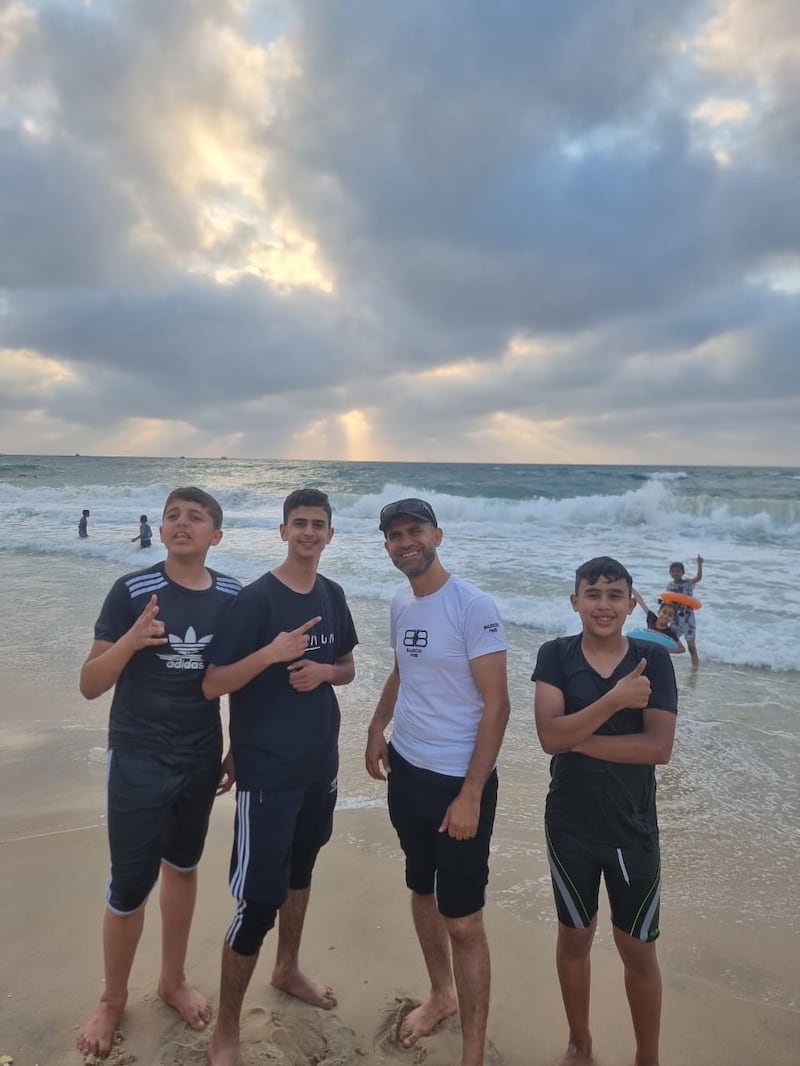 Dr Mahmoud Abumarzouq (in white t-shirt), photographed when on a visit to Gaza in 2023. His nephew Refat is on his left and another nephew Mohamed is on on his right. Both teenagers were killed in an Israeli airstrike on Monday night.