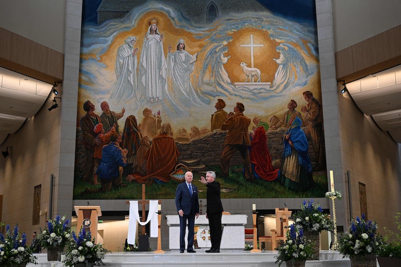 US President Joe Biden speaks with Father Richard Gibbons in front of the mosaic as he visits Knock Shrine on the last day of a four-day trip to Northern Ireland and Ireland. (Photo by Jim WATSON / AFP) 