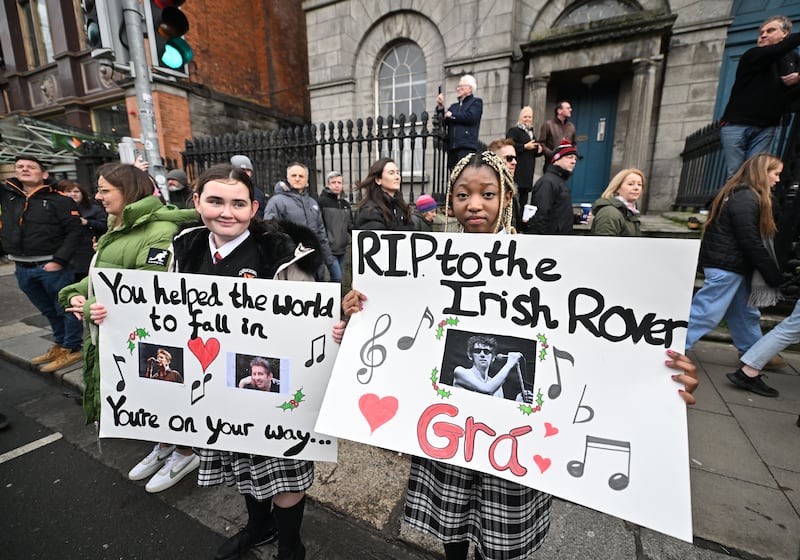 Mourners display messages on placards during the funeral procession. Photograph: Charles McQuillan/Getty