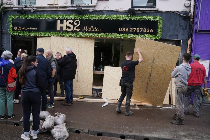 People assist in the clean-up operation on Main street in Midleton last month. Photograph: Brian Lawless/PA Wire