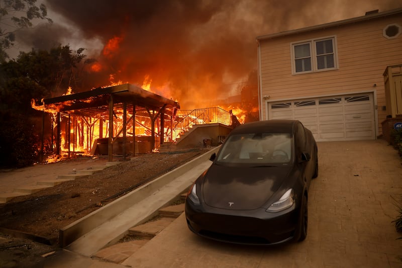 The dire burns a structure in the wealthy Pacific Palisades neighborhood of Los Angeles. Photograph: Etienne Laurent/AP