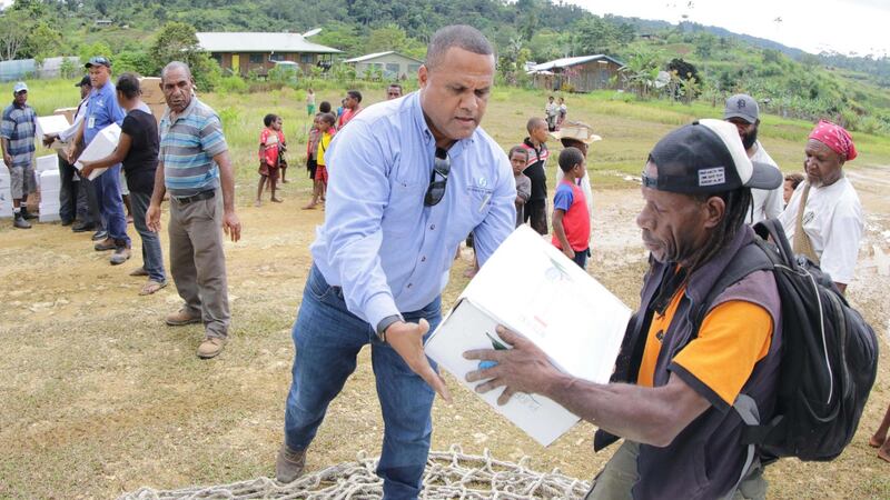 Oil Search staff helping locals distribute supplies from Oil Search and the Australian government in Papua New Guinea. Photograph: AFP/Getty Images