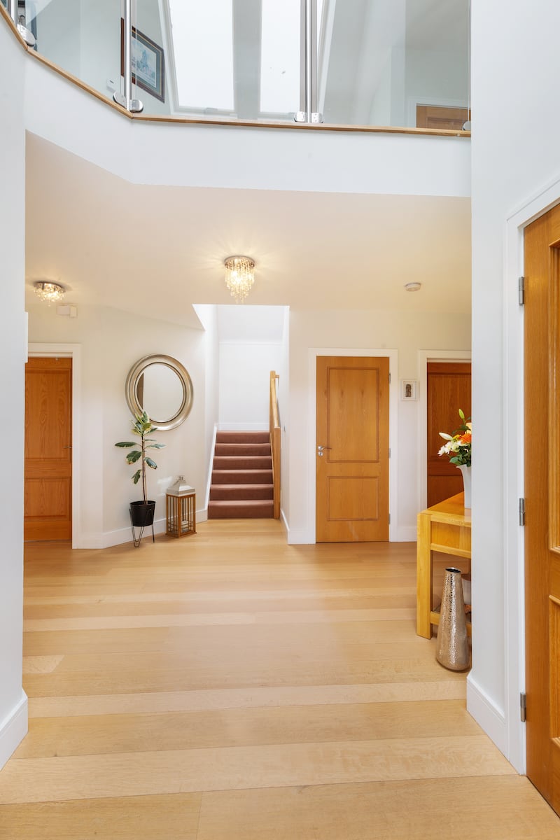 The spacious front hallway is double height with solid American oak flooring