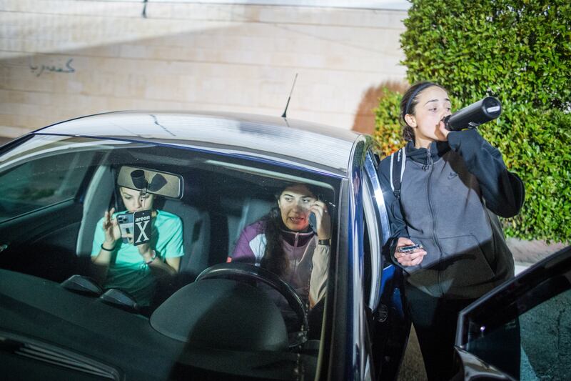 Leen Khouri, right, a player for Sareyet Ramallah and the Palestine under-16 girls' national team as she awaits the arrival of a taxi that will take her home to Jerusalem after passing through Israel's separation wall. Photograph: Giacomo Sini