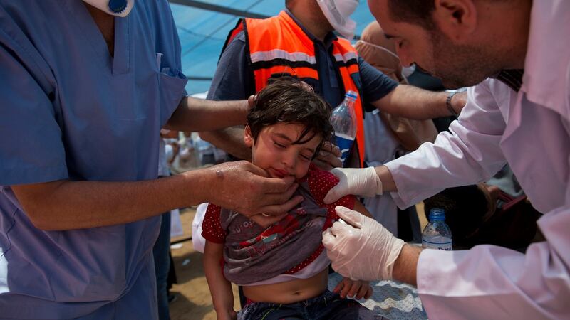 Medics treat a Palestinian child suffering from tear gas inhalation during a protest near Beit Lahiya, Gaza Strip, on Monday. Photograph:  Dusan Vranic/AP