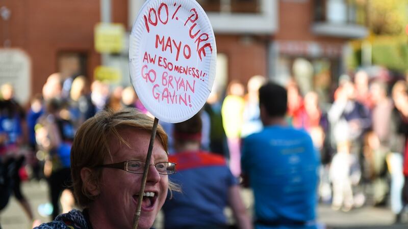 A spectator shouts her encouragement as runners make their way through Chapelizod.  Photograph: David Fitzgerald/Sportsfile