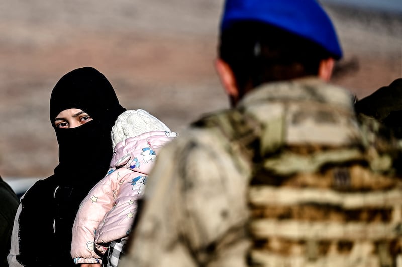 A Syrian woman and her child waiy at the Cilvegozu crossborder gate before entering Syria at the Reyhanli district in Hatay. Photograph: Ozan Kose/AFP/Getty Images