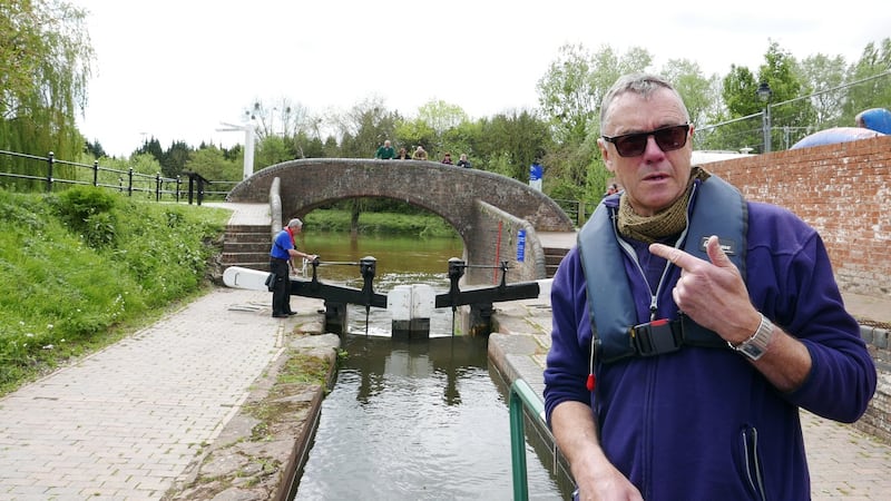 A group of gongoozlers watch the action from a bridge