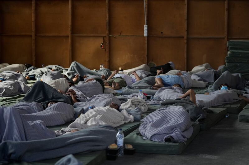 Survivors of a shipwreck sleep at a warehouse at the port in Kalamata, Greece. Photograph: Thanassis Stavrakis/AP