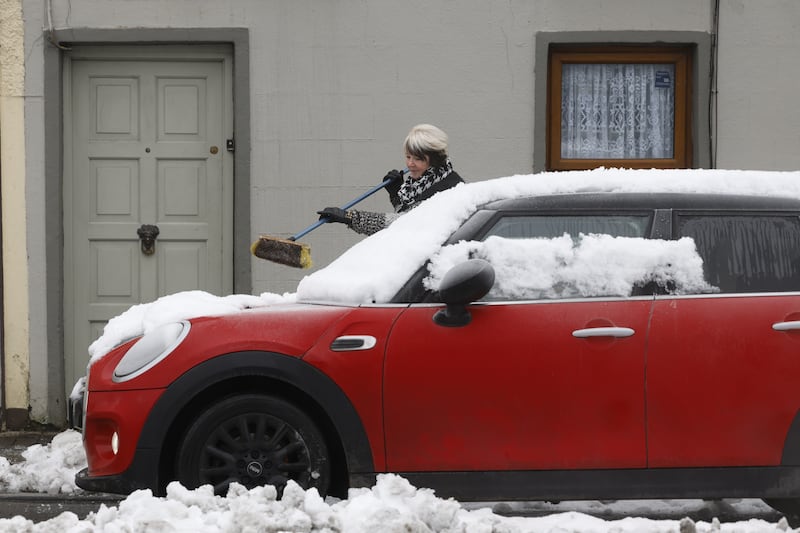 A woman clears snow from her car in Cashel. Photograph: Nick Bradshaw/The Irish Times