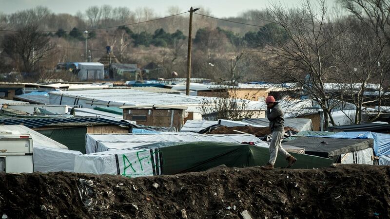 A migrant walks on an embankment of earth surrounding the Jungle migrants and refugee camp in Calais. Photograph: AFP