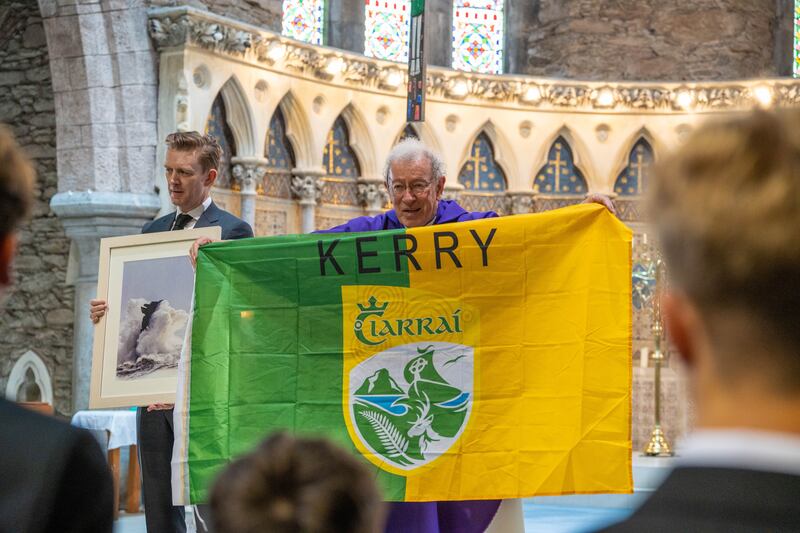 Fr Tom Looney holds up a Kerry flag during the funeral. Photograph: Noel Sweeney/PA Wire 